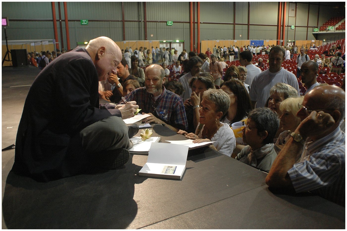 Le Dr Raymond Moody signant des livres, entoure du public, Martigues 2006
